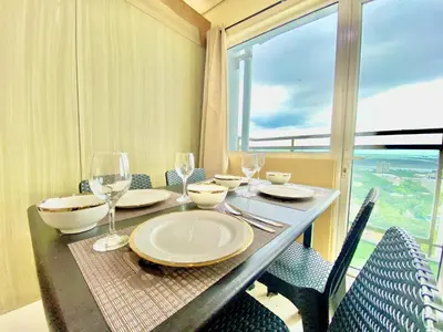 a table with wine glasses and a table with chairs at SMDC BREEZE RESIDENCES Pasay near AIRPORT PICC CCP WORLD TRADE CENTER MOA AND STARCITY in Manila