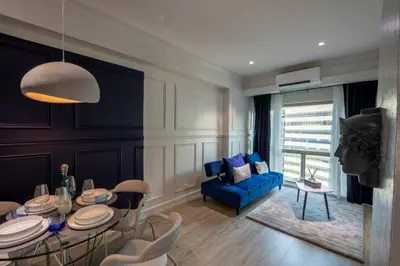 a living room with a table and a blue couch at BGC Designer Pad Near Shops Dining Nightlife in Manila