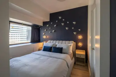 a bedroom with a bed with butterflies on the wall at BGC Designer Pad Near Shops Dining Nightlife in Manila