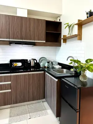 a kitchen with wooden cabinets and a sink and a stove at Casa La Vista in Manila