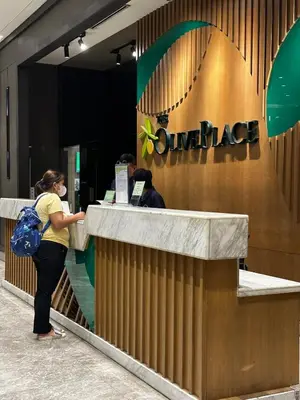 a woman is standing at a counter in front of a lobby at Casa La Vista in Manila