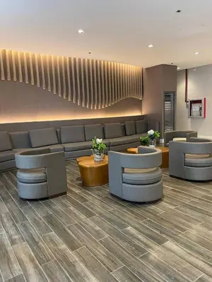 a lobby with a waiting room with couches and tables at The Residence Suite in Manila