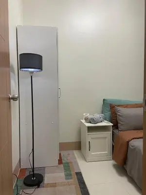 a room with a lamp and a bed and a table at The Residence Suite in Manila