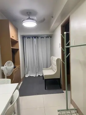 a waiting room with a chair and a window at The Residence Suite in Manila