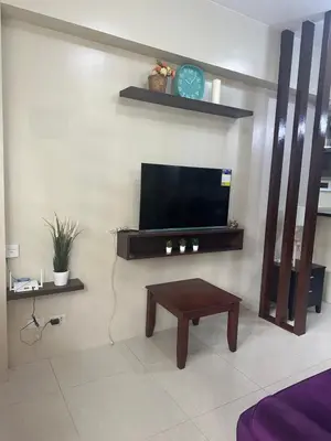 a living room with a tv and a coffee table at Relax Here! STUDIO TYPE in Manila
