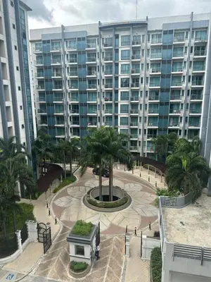 a large building with a palm tree in a courtyard at Relax Here! STUDIO TYPE in Manila