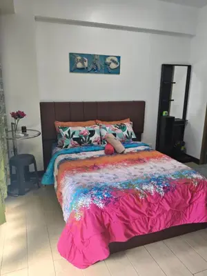 a bed with a teddy bear sitting on top of it at LDN Two Palm Tree Newport Home in Manila