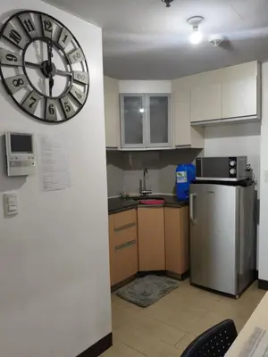 a kitchen with a large clock on the wall at LDN Two Palm Tree Newport Home in Manila