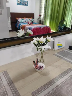a vase of flowers on the floor of a bedroom at LDN Two Palm Tree Newport Home in Manila