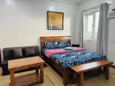 a bedroom with a bed and a couch and a window at Happy Stays E - 300mbps - 65