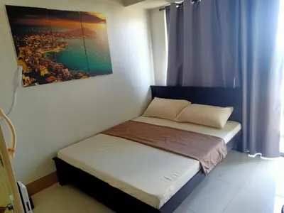 a bedroom with two beds and a painting on the wall at Len's Den 3 Entire Flat in Mall of Asia Pasay Manila in Manila