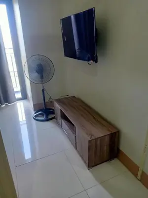 a living room with a tv and a fan at Len's Den 3 Entire Flat in Mall of Asia Pasay Manila in Manila