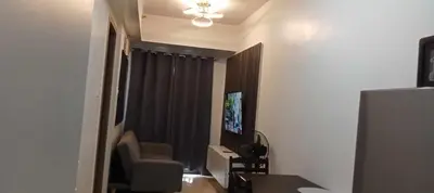 a room with a television and a chair and a window at S Residences Tower 1 Staycation in Manila