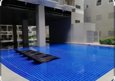 a large swimming pool with blue water in a building at S Residences Tower 1 Staycation in Manila