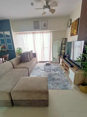 a living room with a couch and a tv at Family-Ready Skyline Retreat near BGC with Free Parking in Manila
