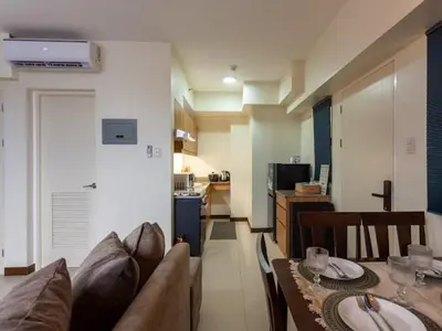 a living room with a couch and a table at Family-Ready Skyline Retreat near BGC with Free Parking in Manila