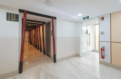 an empty hallway in a building with a fire extinguisher at Maine Residences Tramo near NAIA Terminal in Manila