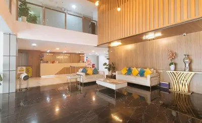 a living room with two couches and yellow pillows at Maine Residences Tramo near NAIA Terminal in Manila