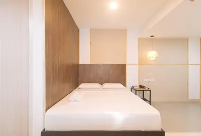 a bedroom with a bed with a wooden wall at Maine Residences Tramo near NAIA Terminal in Manila