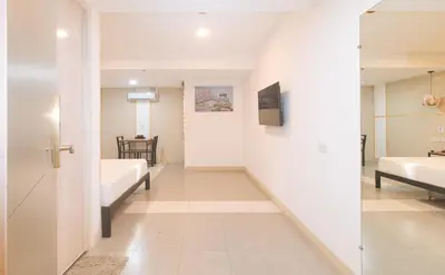 a room with two beds and a hallway at Maine Residences Tramo near NAIA Terminal in Manila
