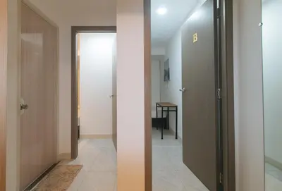 a hallway with two doors and a room with a table at Maine Residences Tramo near NAIA Terminal in Manila