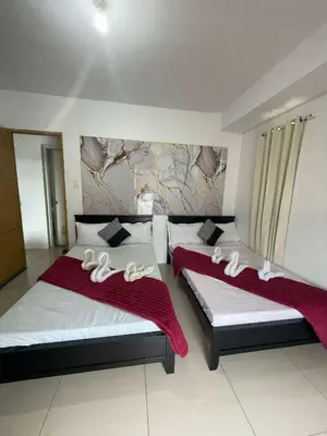 a bedroom with two beds with white towels on them at 1158-2Br 6beds 2 extra mattress 2-sofa in Manila