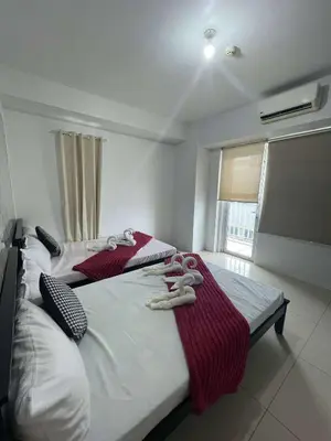 two beds in a bedroom with towels on them at 1158-2Br 6beds 2 extra mattress 2-sofa in Manila