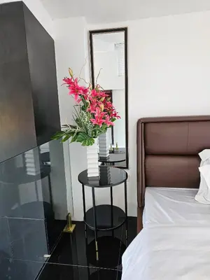 a vase of flowers on a table next to a bed at Casa Prinza Luxury Suite in Teresa