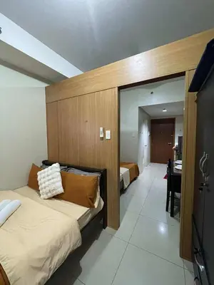 a bedroom with a bed and a desk in a room at 1br big cut 1524D Window Edsa Moa 2beds Queen size 1pullout 1extra mattress in Manila