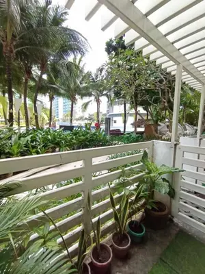 a white fence with plants and palm trees at azure beach front view in Manila