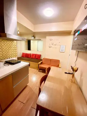 a kitchen and living room with a table and a couch at azure city view 2bedroom in Manila