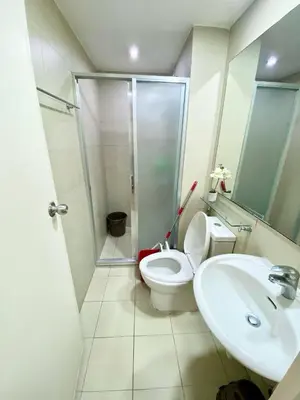 a bathroom with a shower and a toilet and a sink at azure city view 2bedroom in Manila