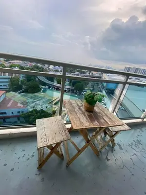 a picnic table on a balcony with a view of the water at azure city view 2bedroom in Manila