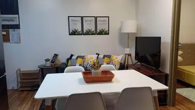 a living room with a white table and a tv at Your Home Away from Home in Manila
