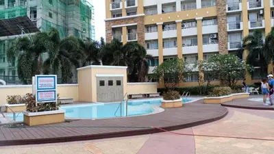 a building with a swimming pool in front of a building at Your Home Away from Home in Manila