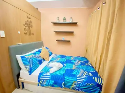 a bedroom with a bed with a blue and white comforter at 1528-1br-1bed-1sofa bed 1pull out pool view with balcony in Manila
