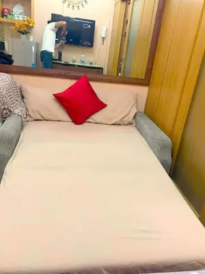 a bed in a room with a red pillow on it at 1528-1br-1bed-1sofa bed 1pull out pool view with balcony in Manila