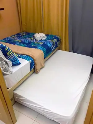 two beds sitting next to each other in a room at 1528-1br-1bed-1sofa bed 1pull out pool view with balcony in Manila