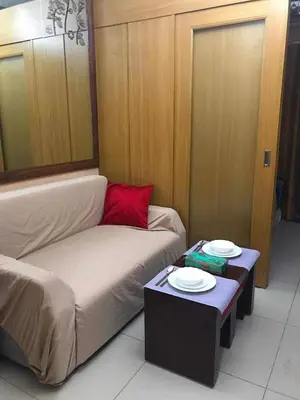 a room with a bed and a table with plates on it at 1528-1br-1bed-1sofa bed 1pull out pool view with balcony in Manila