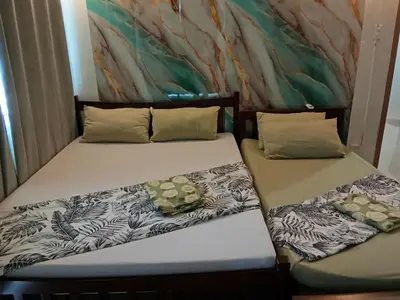 two beds sitting next to each other in a room at 1058-3br-10 beds 1 extra mattress-moa view with balcony in Manila