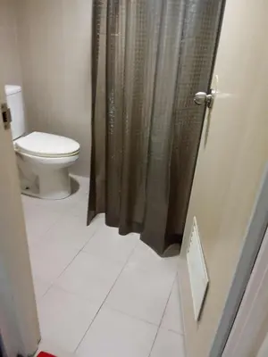 a bathroom with a toilet and a shower curtain at 1058-3br-10 beds 1 extra mattress-moa view with balcony in Manila