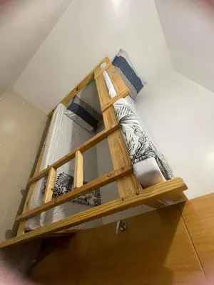 a wooden bunk bed in the corner of a room at 1058-3br-10 beds 1 extra mattress-moa view with balcony in Manila