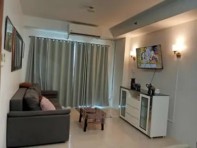 a living room with a couch and a window at 1058-3br-10 beds 1 extra mattress-moa view with balcony in Manila