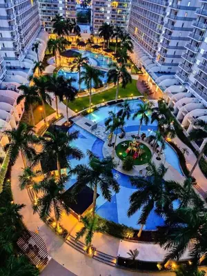 an overhead view of a large pool with palm trees at 1046-2Br 2bed 1extra matress pool view with balcony in Manila