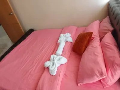 a bed with pink sheets with bows on it at 1046-2Br 2bed 1extra matress pool view with balcony in Manila
