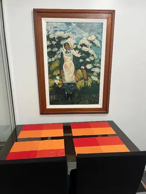a painting on a wall with a table in front of a painting at 1 bedroom azure beachview 6 in Manila