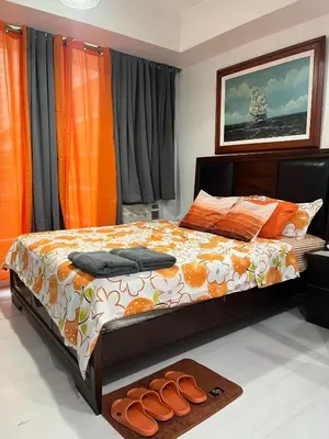 a bedroom with a bed with a pair of shoes on it at 1 bedroom azure beachview 6 in Manila