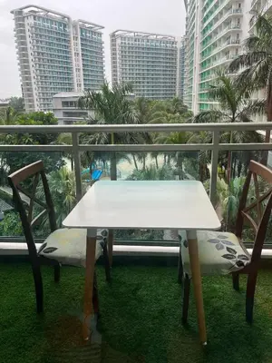 a white table and chairs on a balcony with buildings at 1 bedroom azure beachview 6 in Manila