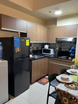 a kitchen with a black refrigerator and a table at Bayview near CCP, PICC, Airport, MOA, Okada at Radiance in Manila