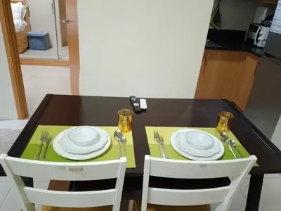a black table with white plates and silverware on it at 101-2Br-1bed quenn-1single-1-pullout 2 sofa 2-cr pool view with balcony in Manila